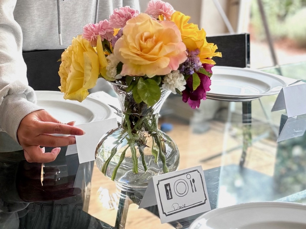 Place card with name written in cursive is placed above the dinner plate for the weekly family dinner.