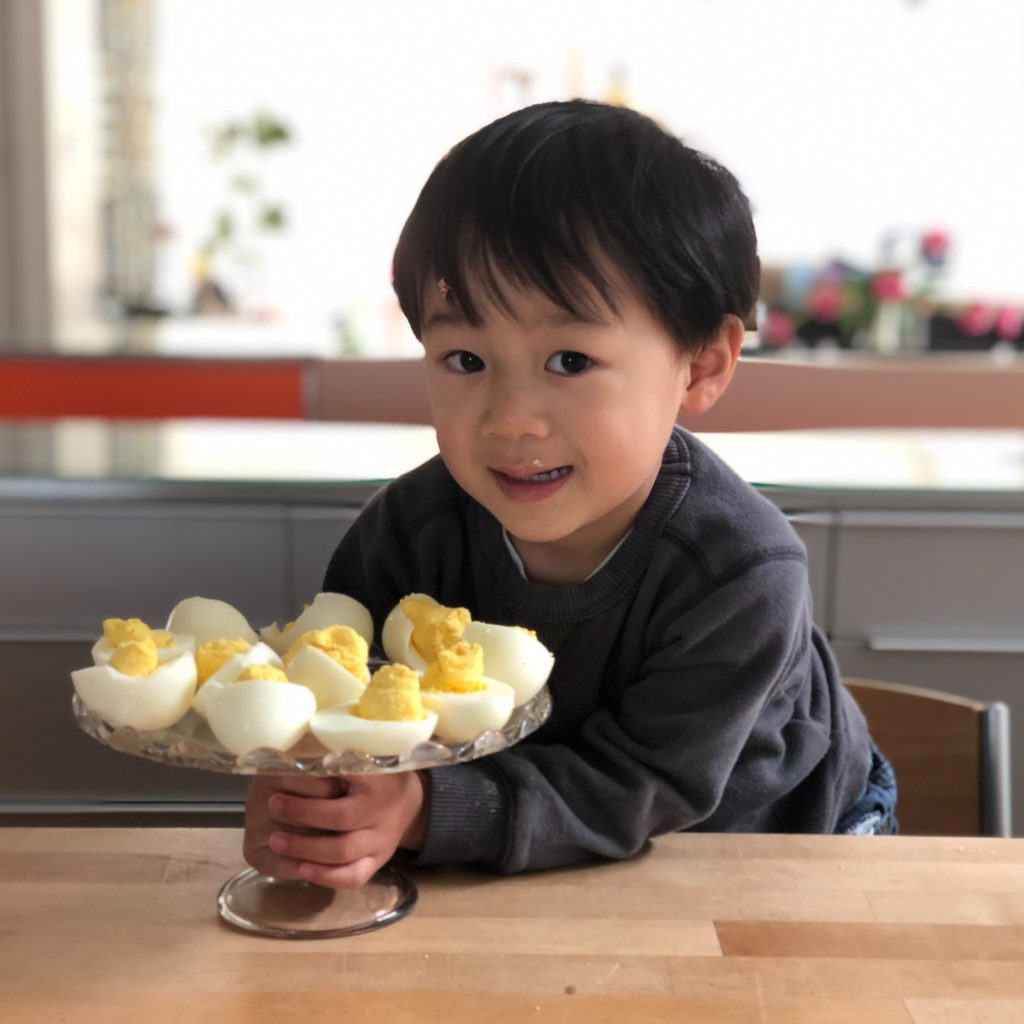 Master N, not quite three, made a plateful of deviled eggs. Kids can begin cooking projects as young as three.