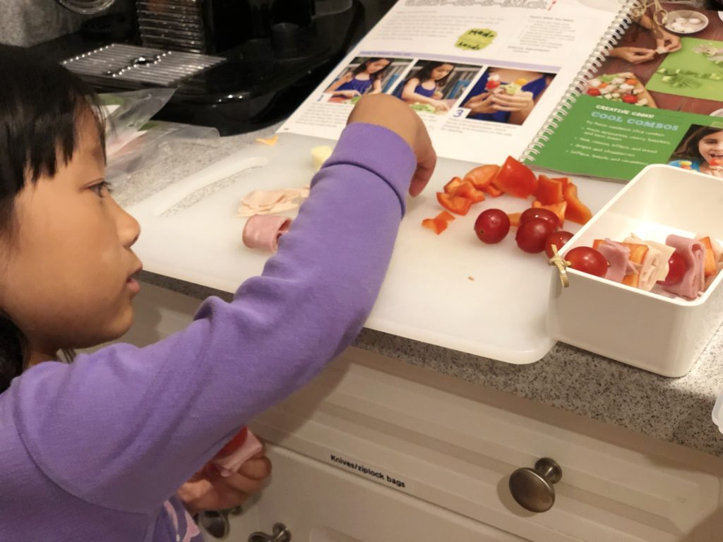 Miss T skewers cold meat slices, cheese and vegetables to make her own back-to-school bento lunch.