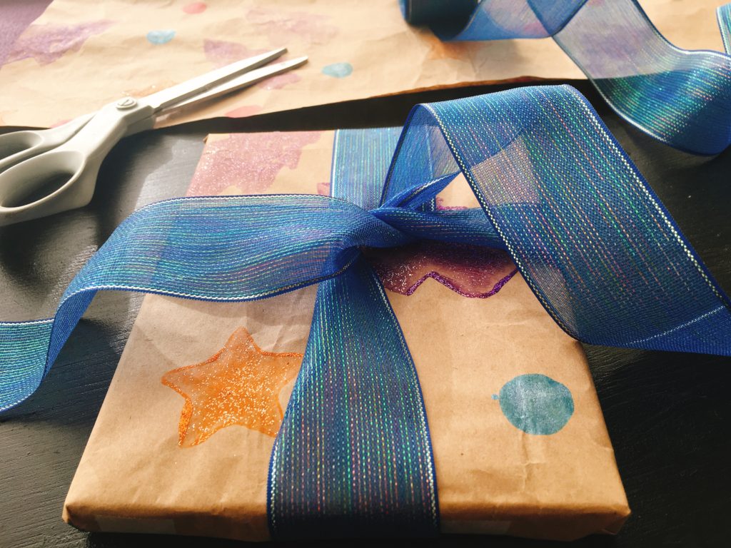 This gift wrap is made from recycled brown packing paper using stamps cut for potatoes.
