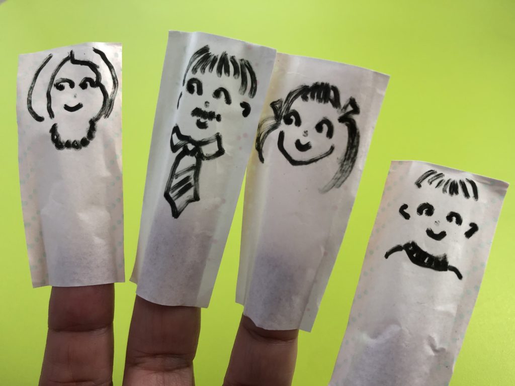 These paper puppets are made from the paper sheaths from wooden chopsticks using a Sharpie to draw the features.