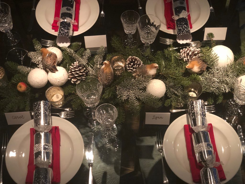 Discarded tree branches and decorative elements like pine cones and partridges create a winter wonderland Christmas centerpiece.