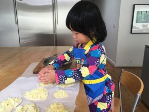 A three-year-old child can help to make pizza for an after-school snack.