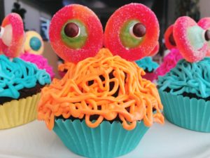 Monster cupcakes are made with strings of frosting and candy eyes.
