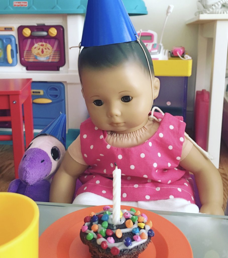 In her own party hat, the doll, Lucy, celebrates her first birthday.