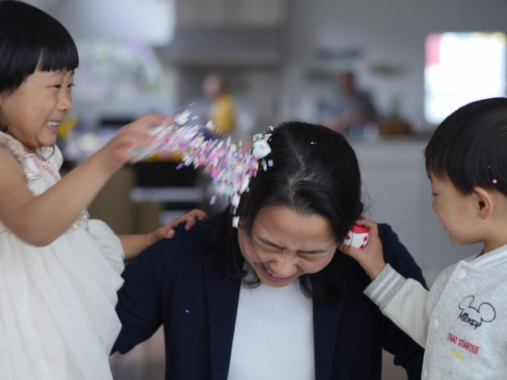 Mommy is bombed on both sides with confetti eggs.