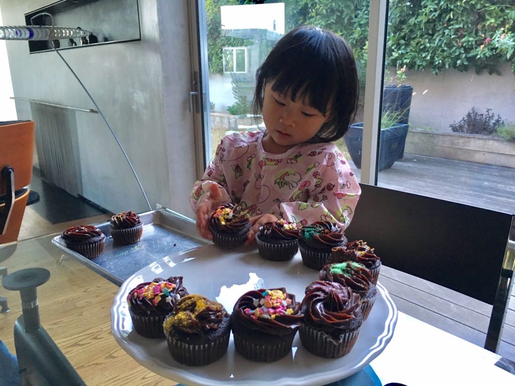 Miss T at four, decorating cupcakes.
