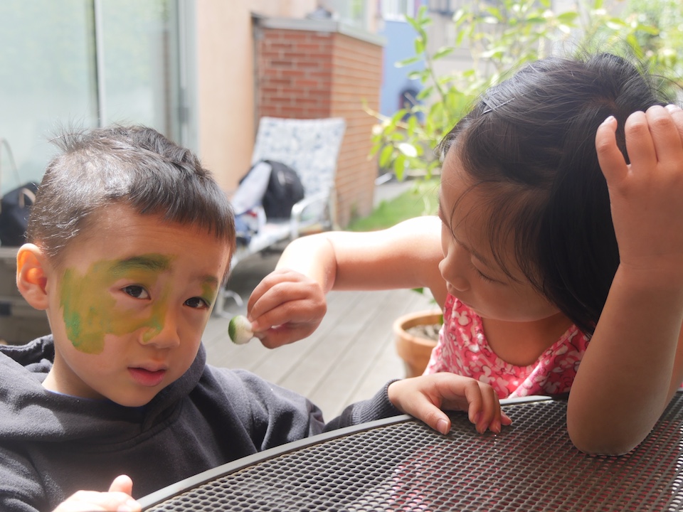 Every summer celebration needs face painting. Miss T paints her little brother's face.
