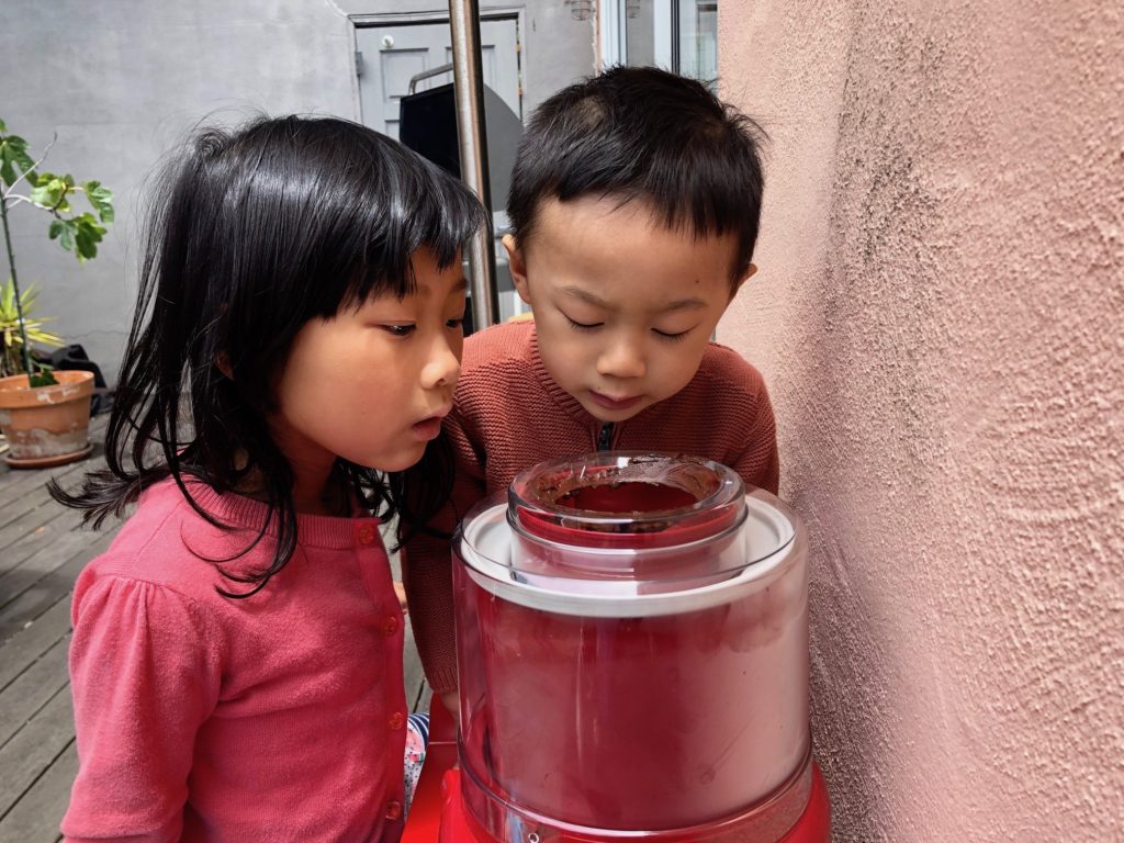 Grandkids watch the ice cream being churned for dessert. In retrospect, not a good idea--especially without masks.