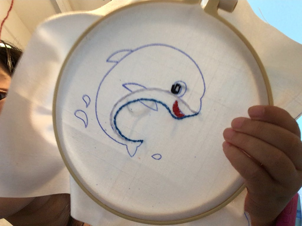Miss T works on her embroidery pattern: a whale.
