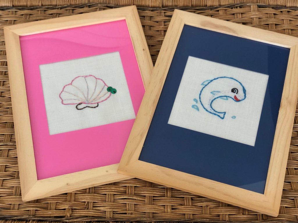 Cheap frames with cardstock mats are used to frame the child's embroidery to showcase her work.