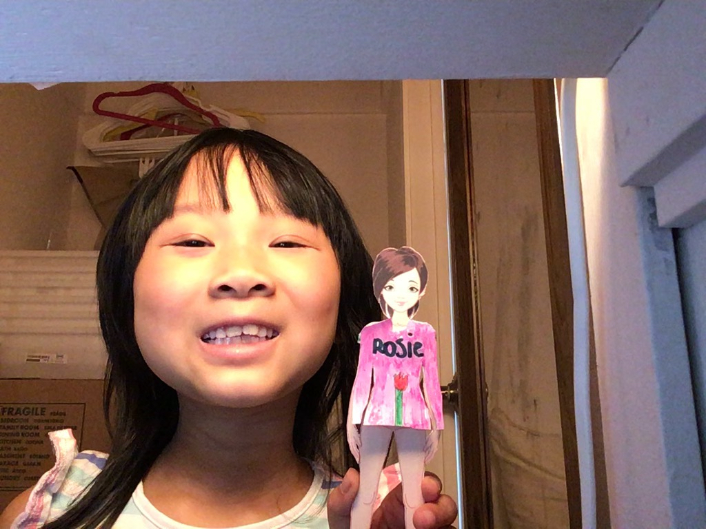 Miss T created a great-looking shirt for her paper doll, Rosie, by writing in her name, drawing a rose, and coloring the rest of the shirt with markers.