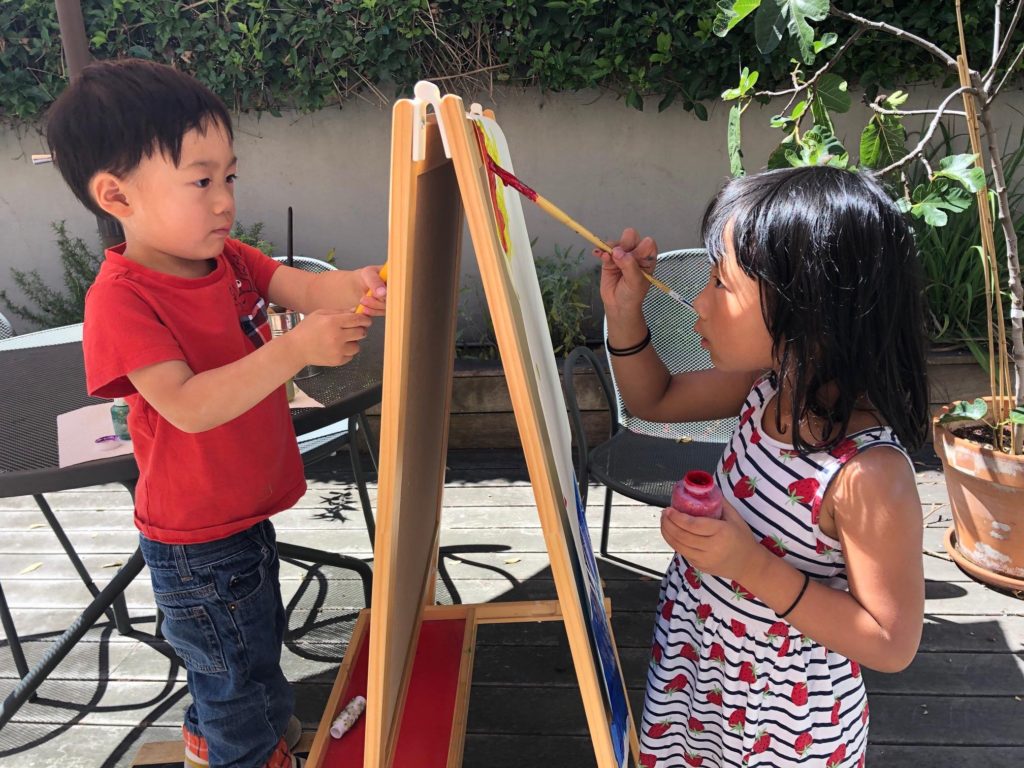 Kids painting at an easel; recycle the artwork into gift wrap.