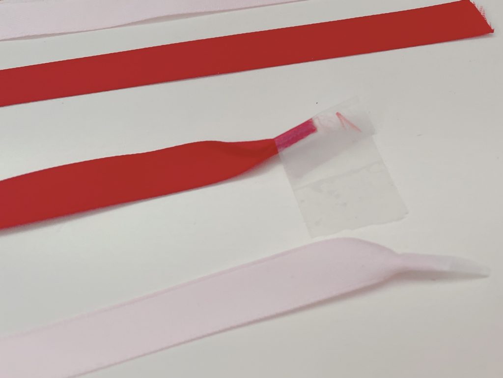If the ribbon is too fat for the punched hole, roll it up, tape it down and snip a point to use as a threader.