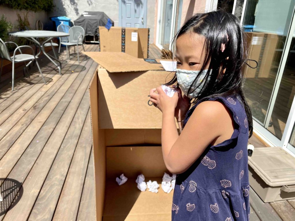 Child preparing an arsenal of recycled paper balls.