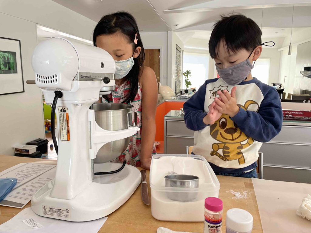 Kids baking cookies. It's a popular activity that grandparents can do with grandkids.