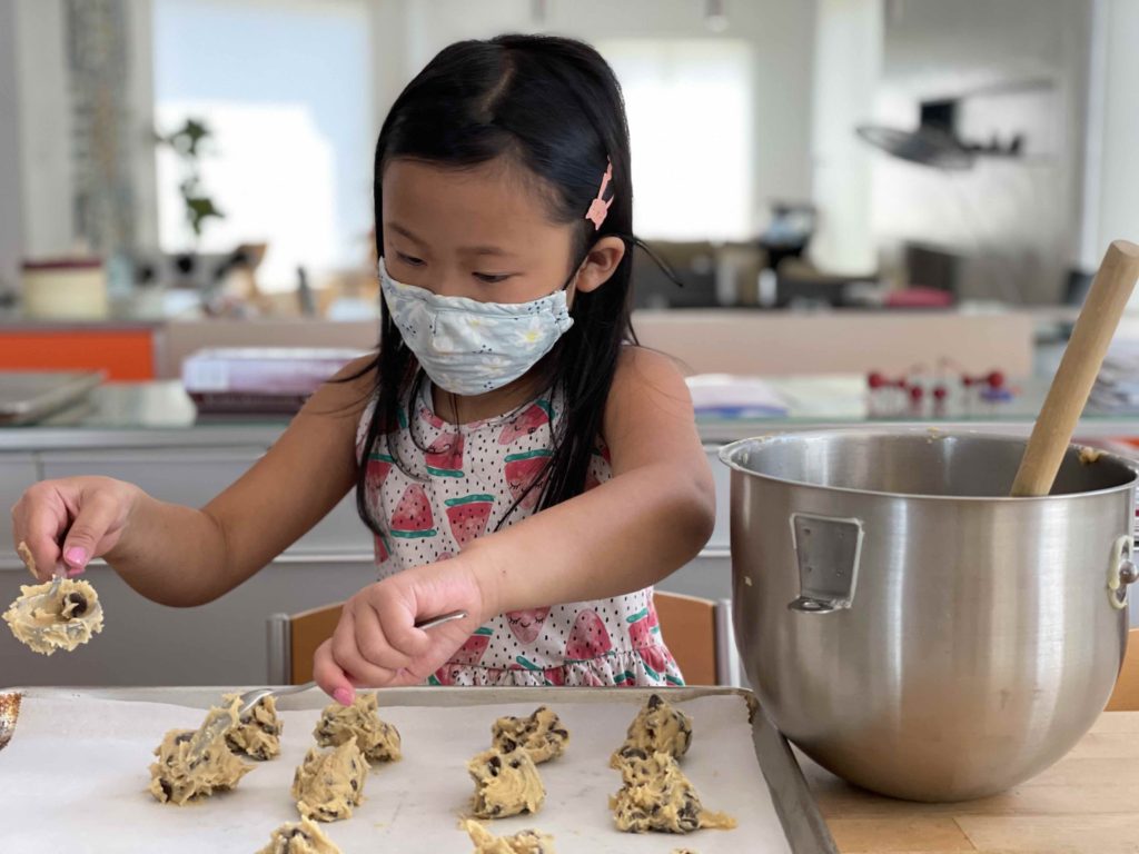 What to do with the grandkids: make cookies! A seven-year-old spooning out dough for chocolate chip cookies.