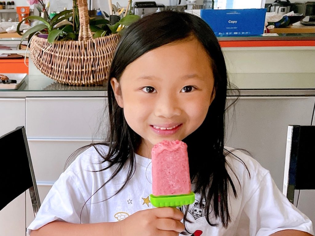 
Child enjoys a strawberries and cream paleta, an easy-to-make summer treat.