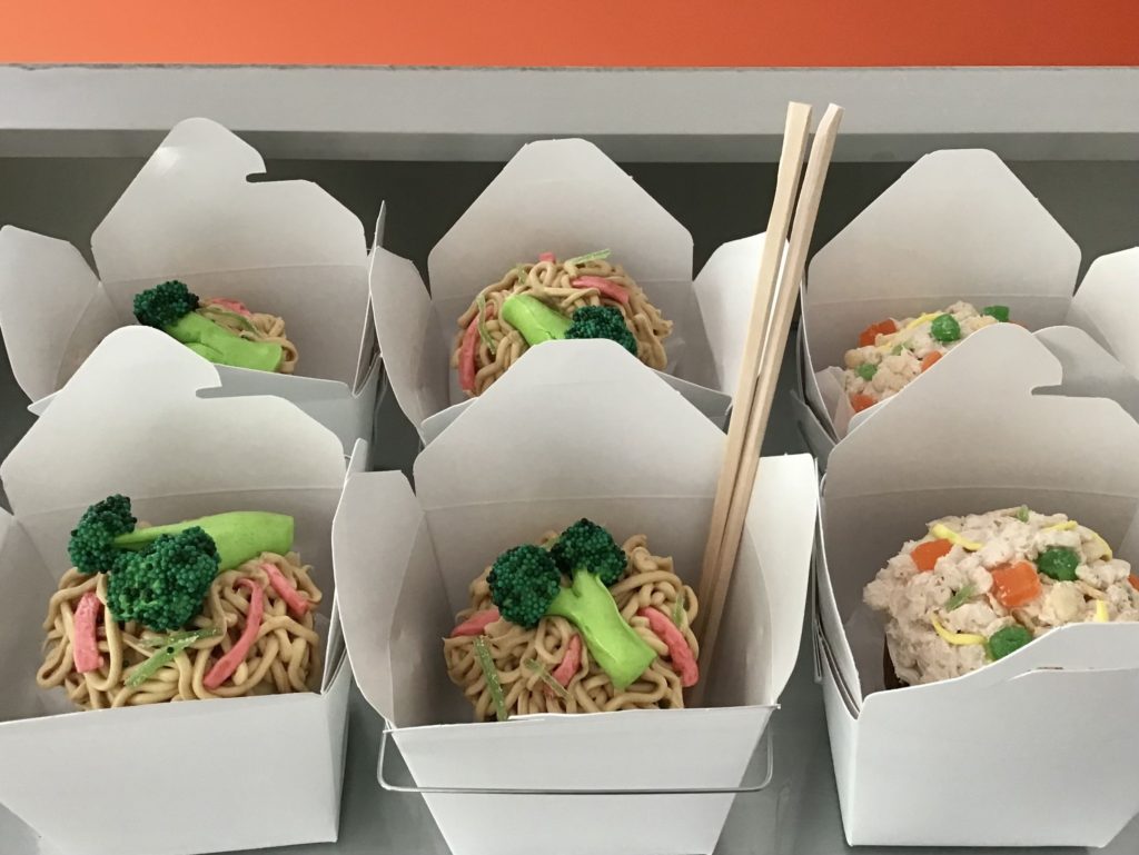 Cupcakes for a child's birthday look like Chinese takeout food, but are made with frosting noodles, candy for broccoli and rice crispies for fried rice.