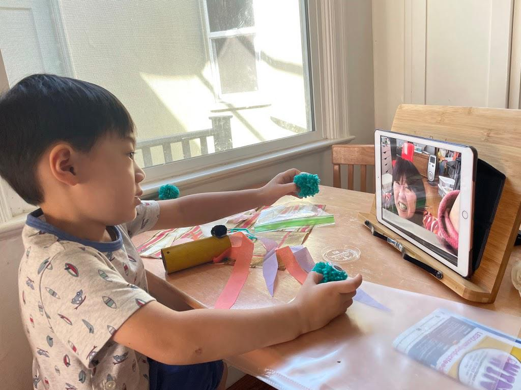 Grandma shows her grandchild how to make a craft project over FaceTime on an iPad.