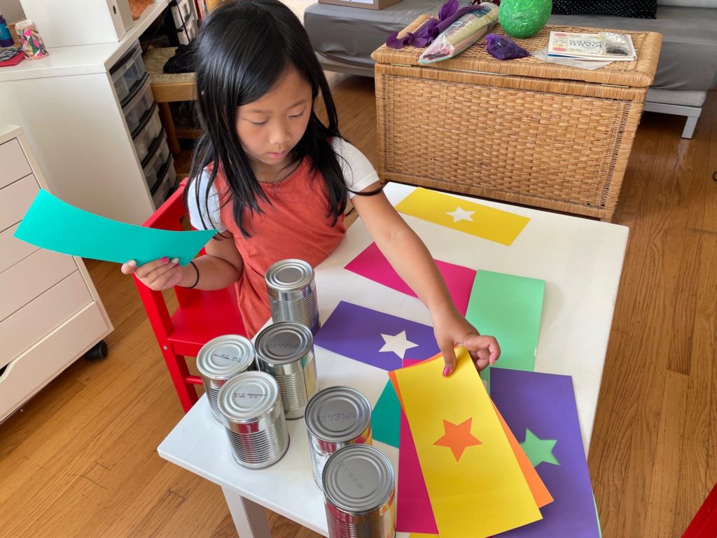 Child arranges cardstock to get ready for covering.