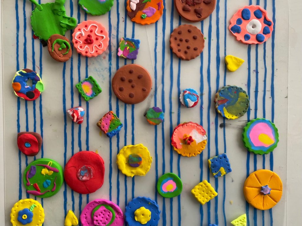 A variety of colorful cookies air drying on a plastic mat.