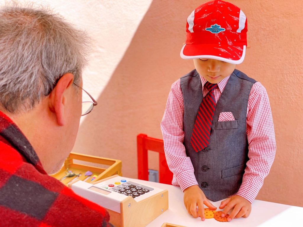 Grandpa buys cookies for the little cookie shop proprietor.