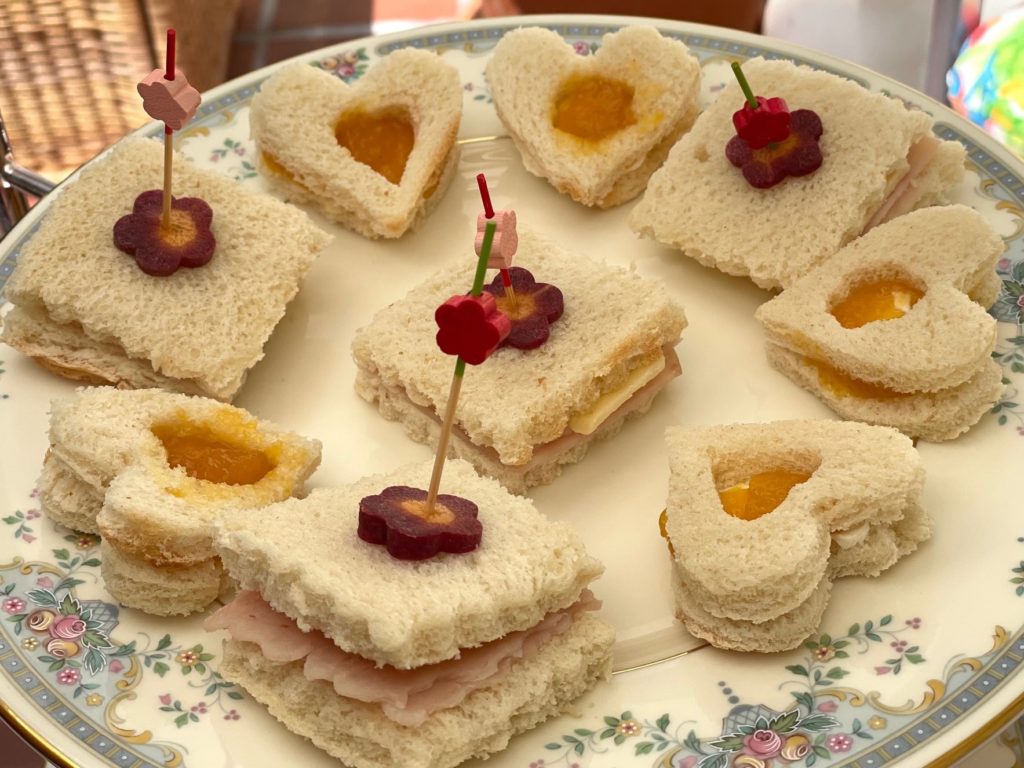 A selection of tea sandwiches: mango jam and cream cheese, and turkey and cheese.