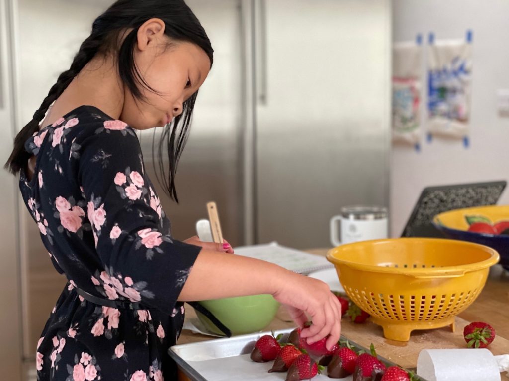 Chocolate-dipped strawberries made by a child for a kids tea party.