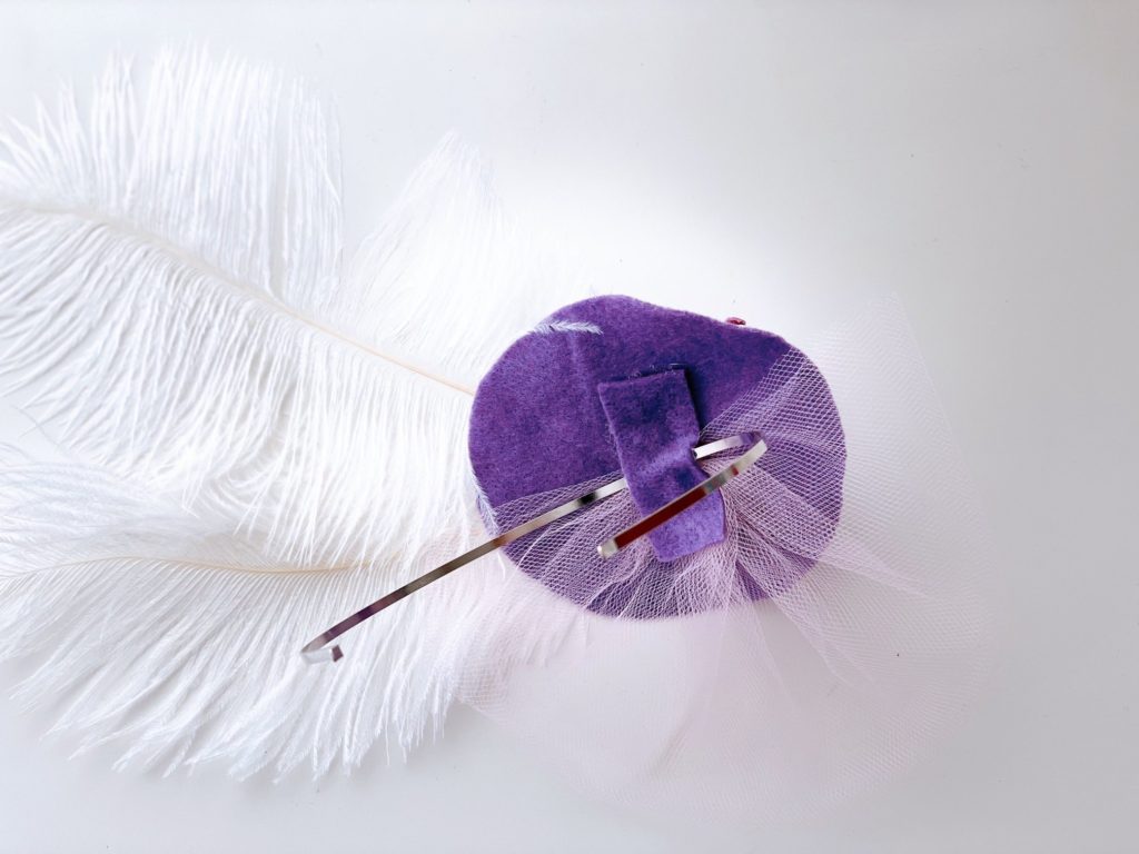 The underside of the small fascinator shows how a felt strip is glued on to hold the headband.