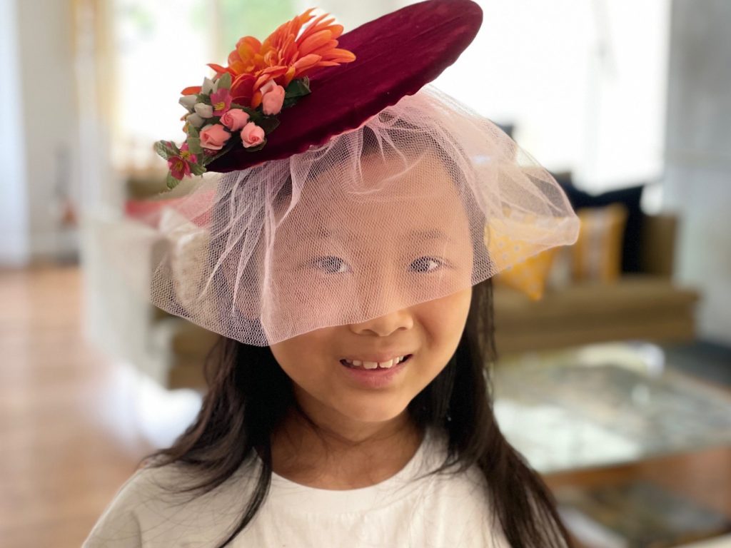 A finished fascinator with flowers and a tulle veil; follow the steps to learn how to make fascinators, from start to finish.