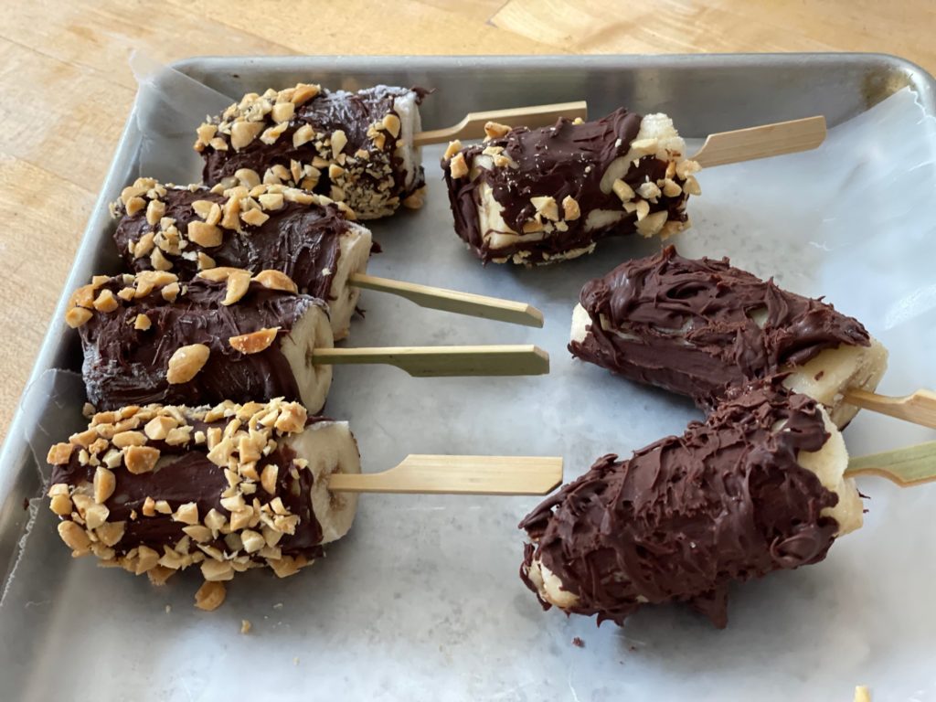 Coat frozen bananas in melted chocolate chips and roll in nuts.