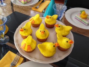 Rubber duckies are cupcakes topped with doughnut holes for the heads, then dipped in melted frosting.