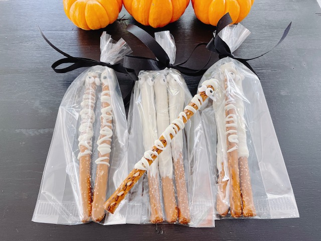 Halloween mummies are made with pretzel sicks and white chocolate.