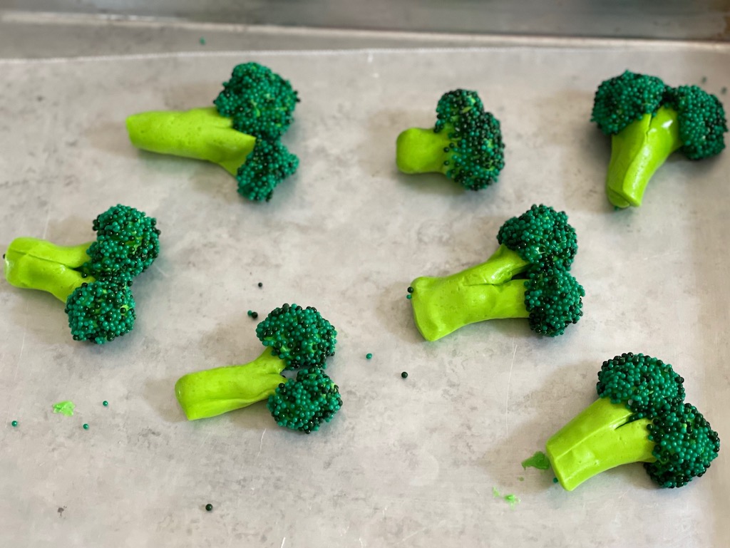 To make broccoli, split green fruit chews to create broccoli stalks; heads are green sprinkles attached with frosting.