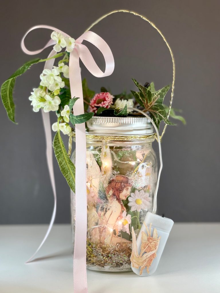 The finished fairy lantern, decorated with flowers, leaves, and ribbon.