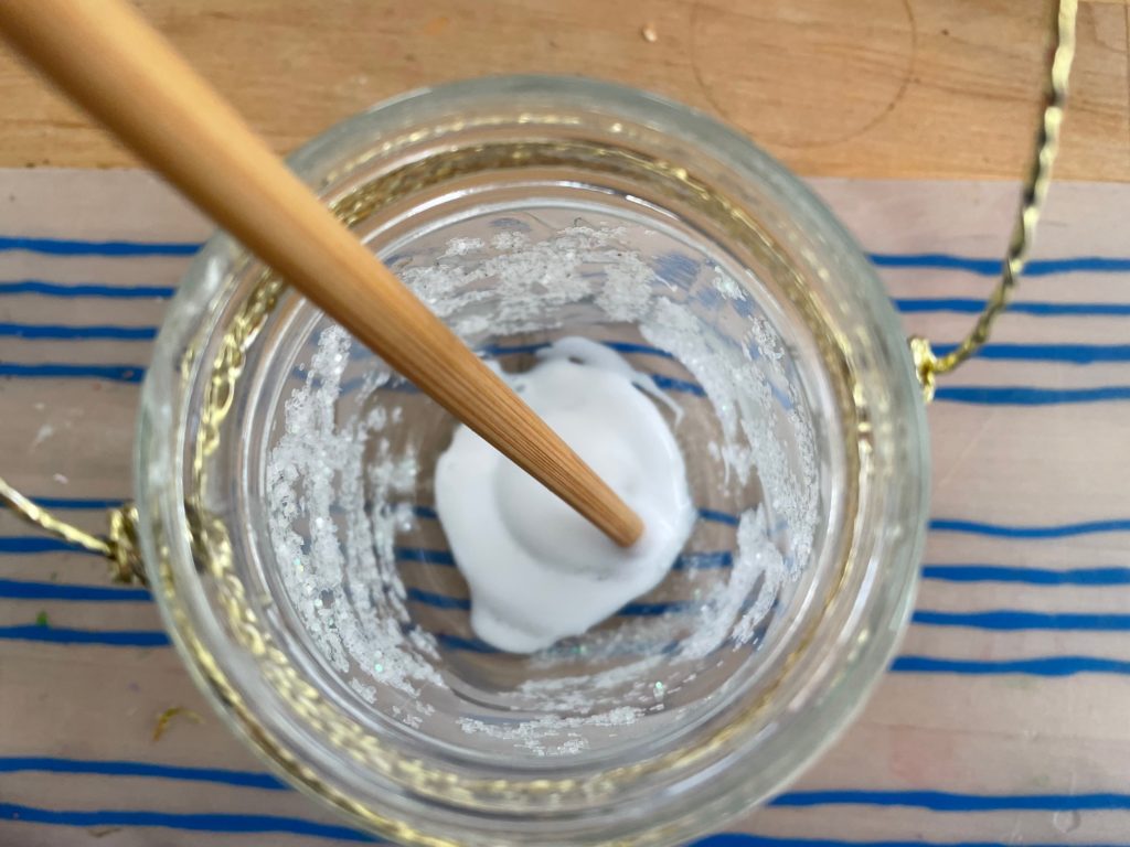 Pour white glue into the bottom of the mason jar, spread with a chopstick to cover the entire bottom.