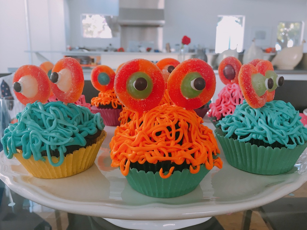 Cupcake monsters are made with strings of frosting and candy eyes.