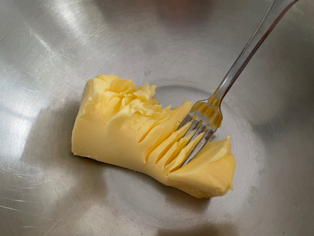 To cream butter by hand, start by mashing butter with a fork. Add half the amount of sugar first to get the process started, then add the remainder and cream until butter is light and fluffy.