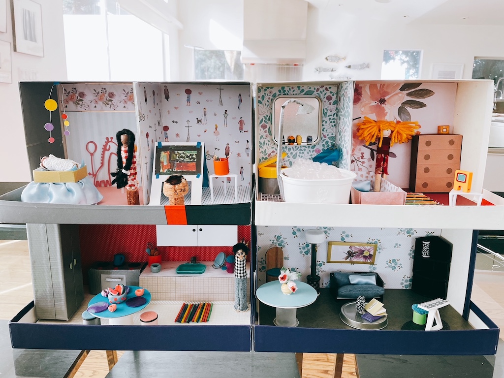 The DIY dollhouse has a nursery, art studio, bathroom and bedroom on the top floor; kitchen and living room below.