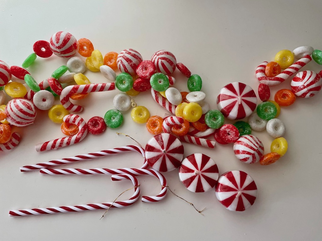Artificial candy garland, candy cane ornaments, and candy-shaped candles are used to enhance the table setting.