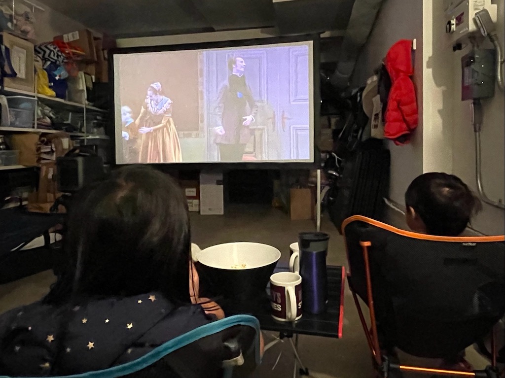 Quarantined kids watch the Nutcracker on a large screen in the garage, since they couldn't go to the Opera House for the performance this year.