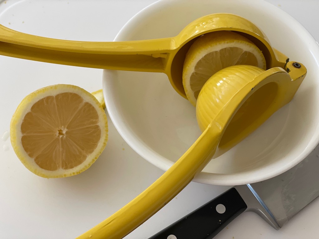 A juice press is a convenient tool for squeezing lemons. Squeeze with cut sides up to extract the most juice.