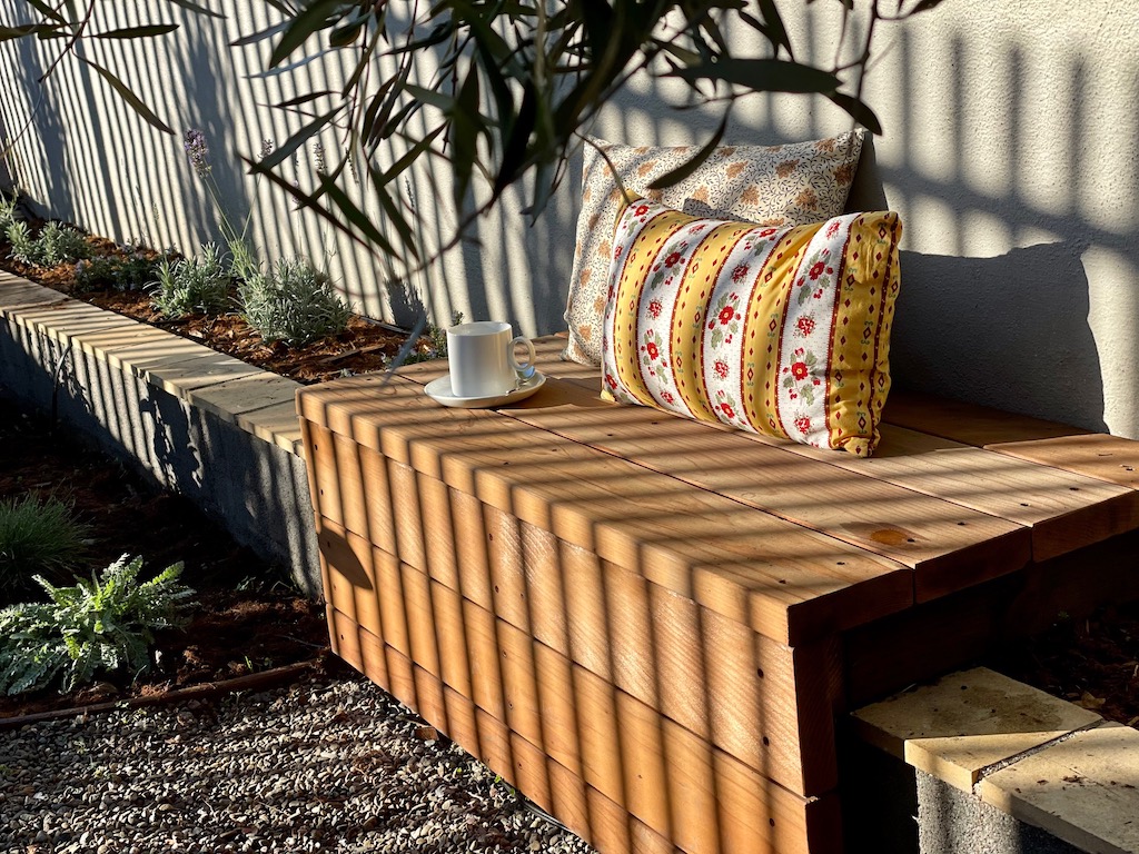 A redwood bench is a good place to sit in the sunshine with a cup of coffee.