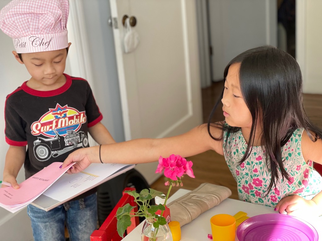 Child returning the menu after ordering.