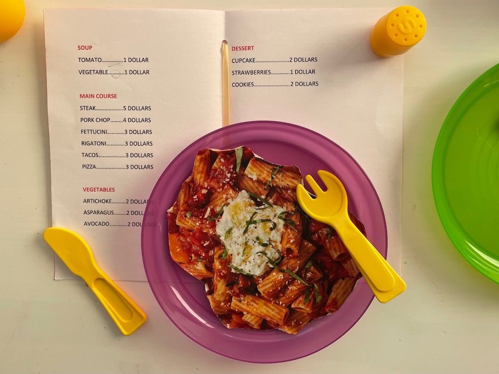 One the plate: rigatoni cut out from a magazine illustration, plus open menu.