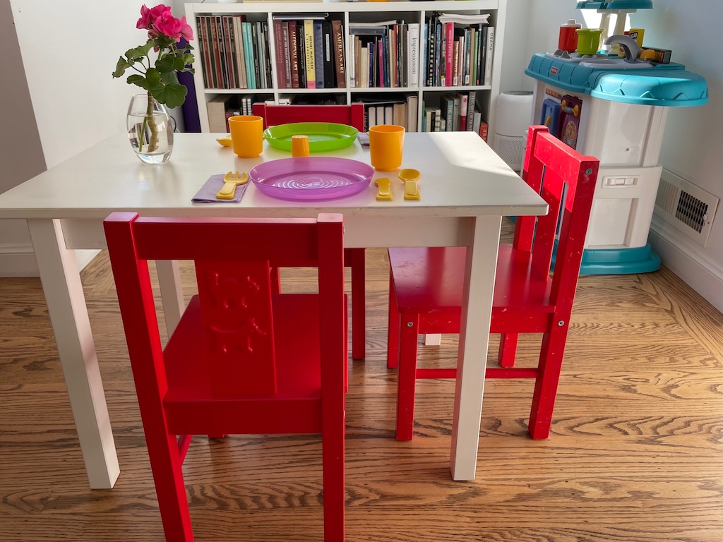 Set up a table and chairs with toy dishes to create the restaurant in a corner of the house.