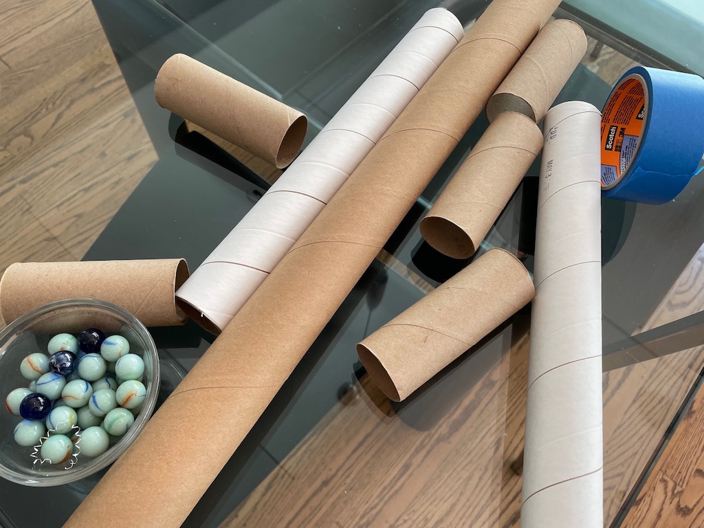 Cardboard tubes of all sizes, painter's tape, and marbles are the main components of our DIY marble run.