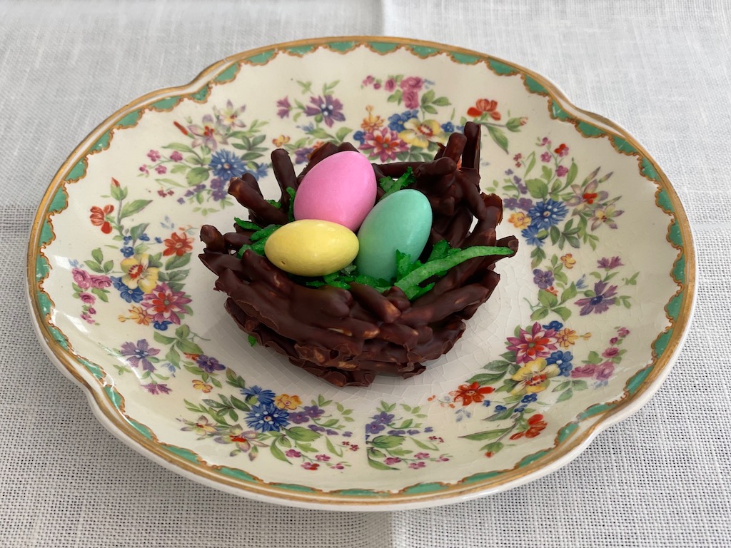 Easter egg nest is made from chow mein noodles coated in chocolate, coconut Easter grass, and Jordan almond eggs.