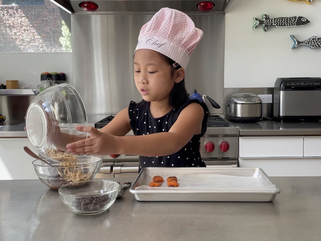 Our child cooking star adds chow mein noodles to remaining chocolate.